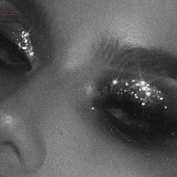 black and white photograph of woman's face with glitter on her eyes