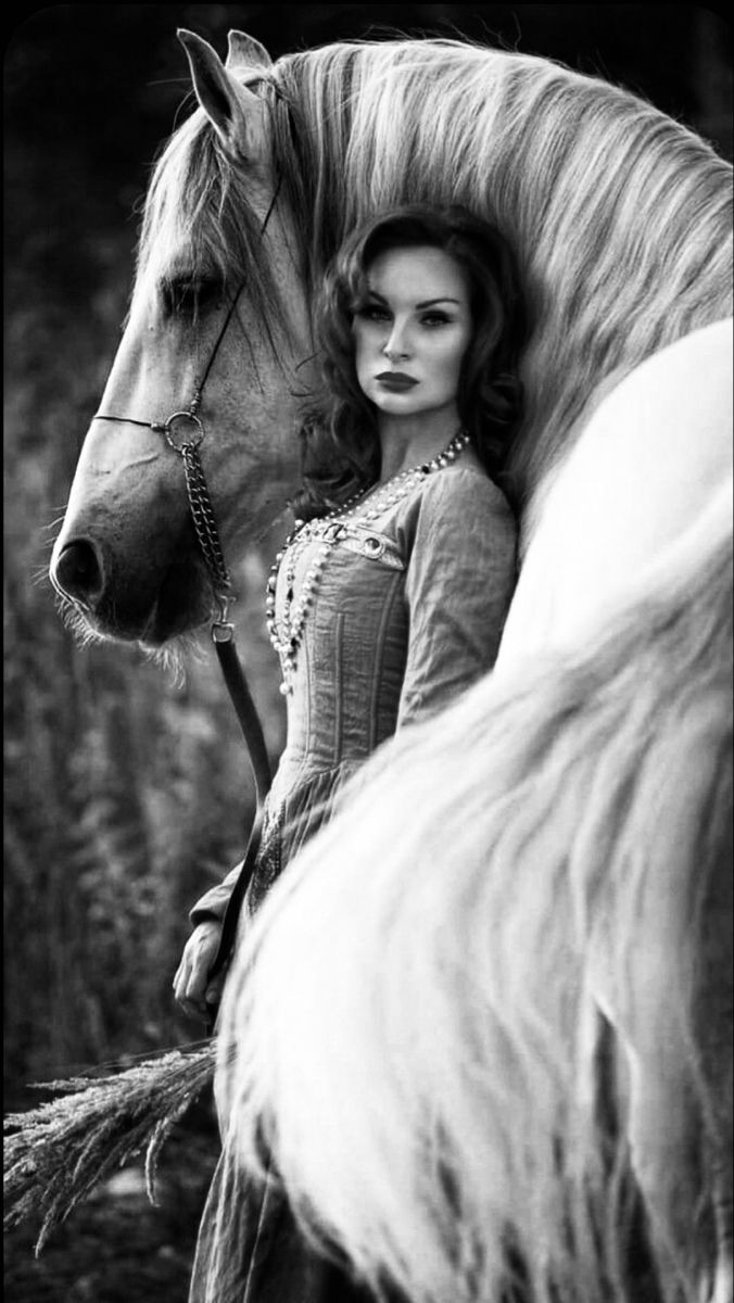 a black and white photo of a woman sitting on a horse