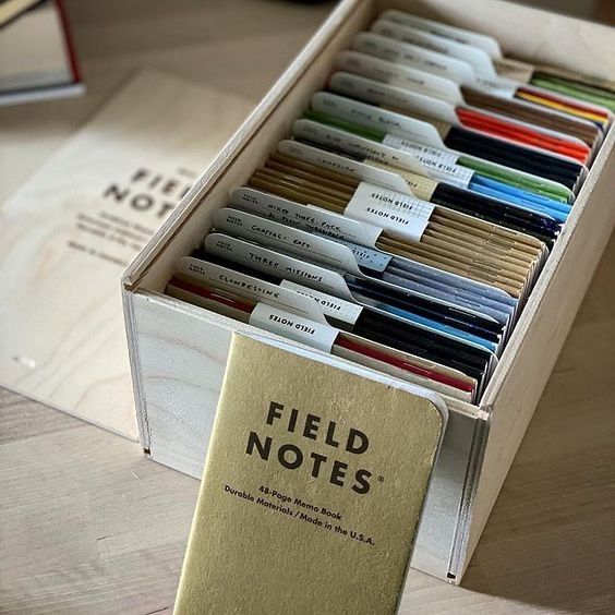 a box filled with lots of books on top of a wooden table