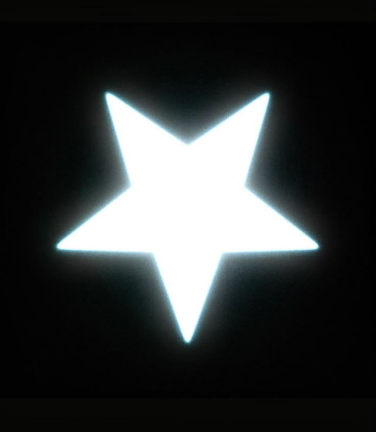 a white star on a black background in the dark