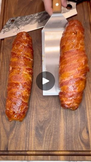 two croissants on a cutting board with a knife