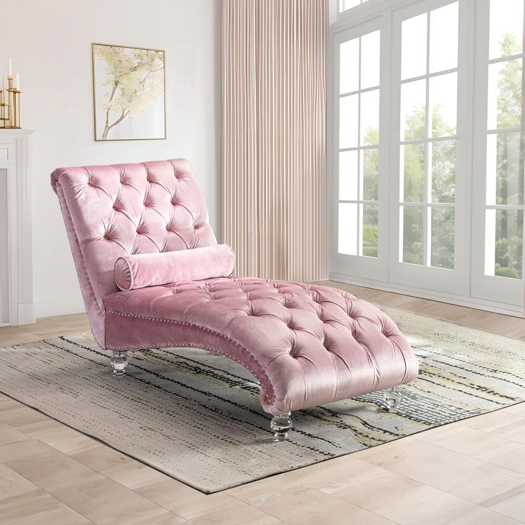 a pink chaise lounge chair sitting on top of a rug