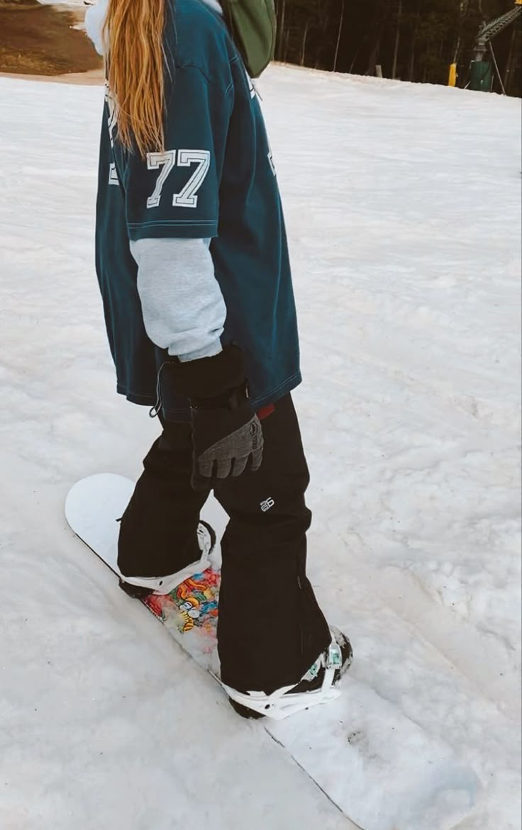 a person on a snowboard standing in the snow