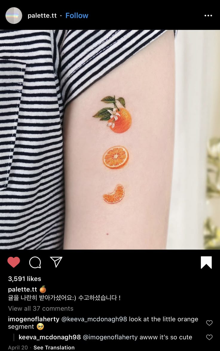 an orange tattoo on the back of a woman's left arm, which is decorated with fruit and leaves