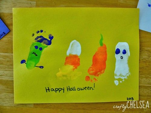 a child's handprinted halloween card with three different colored pumpkins on it