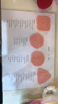 three crocheted hearts are displayed on a piece of paper