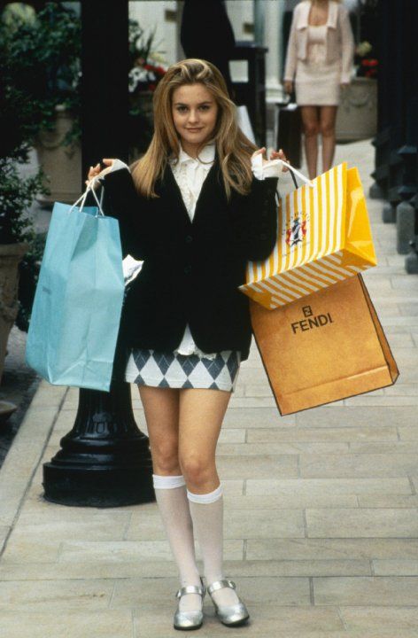 a young woman is holding shopping bags and posing for the camera