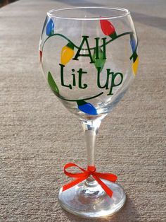 a wine glass with an all lit up design on the bottom and a red ribbon around it