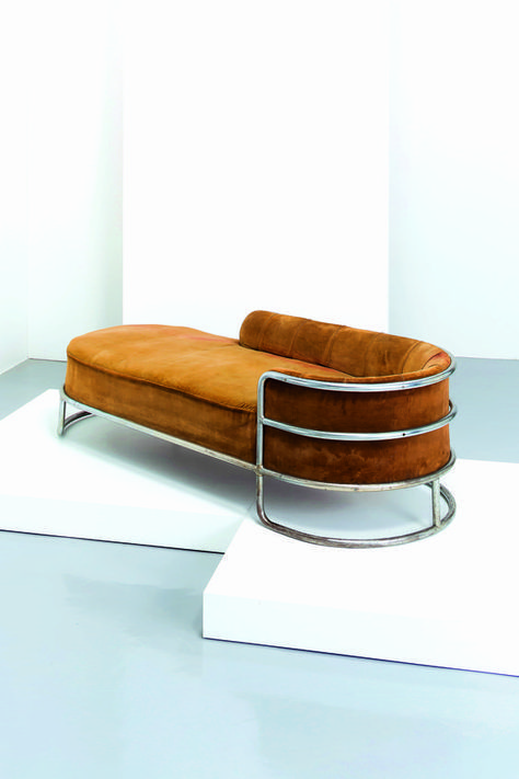 a brown couch sitting on top of a white platform