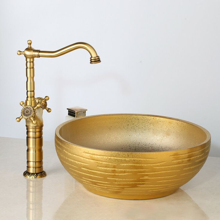 a gold sink and faucet on a white counter