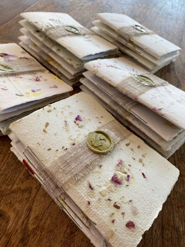 a pile of old papers sitting on top of a wooden table next to a button