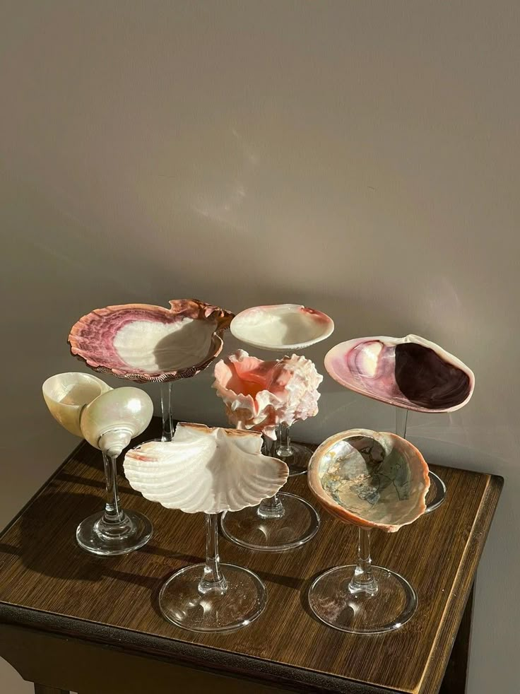 some wine glasses are sitting on a table with seashells and other things in them