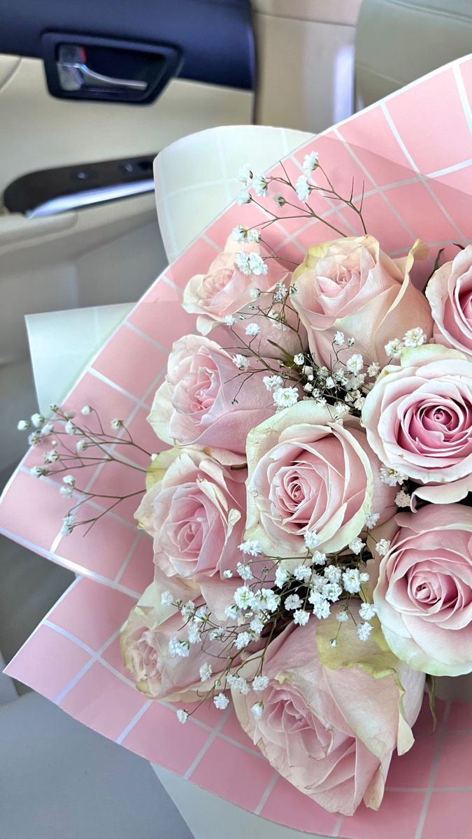 a bouquet of pink roses sitting on top of a table