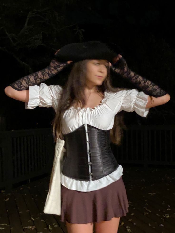 a woman wearing a black and white corset with her hands on her hips