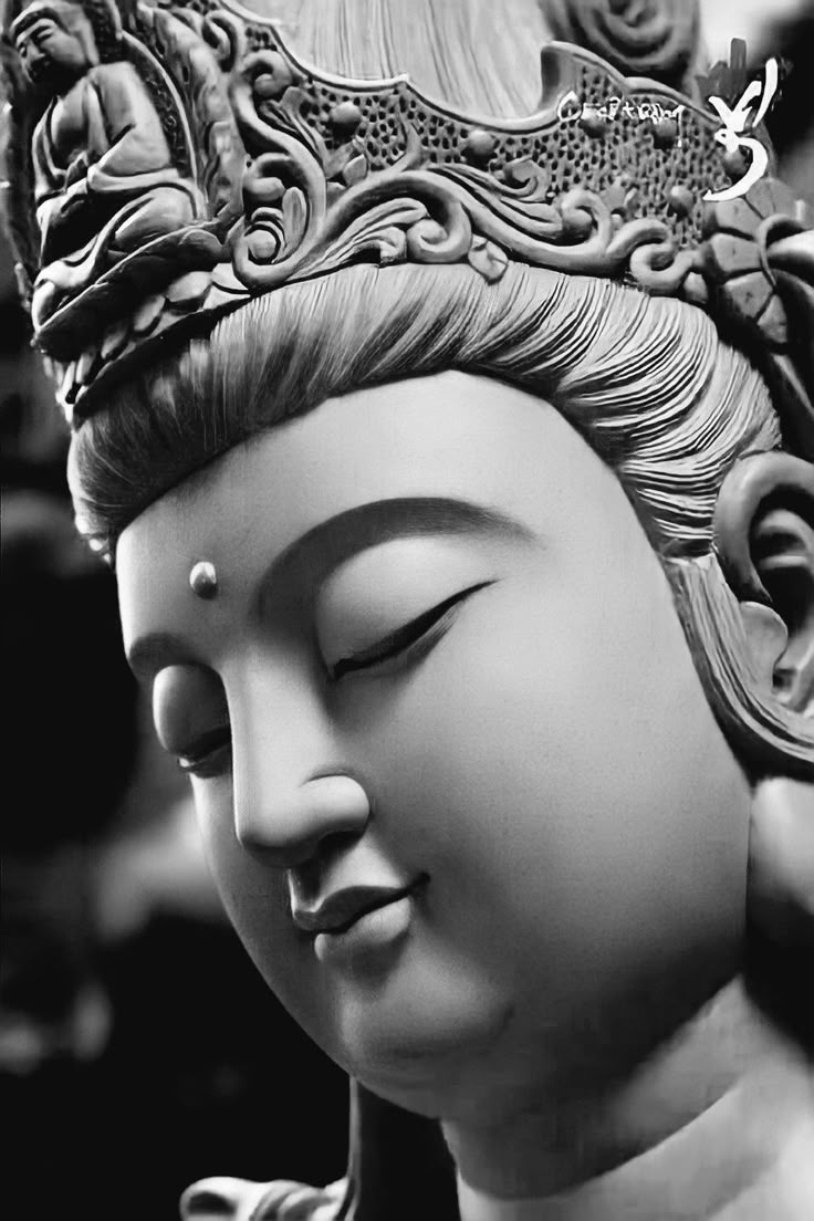 black and white photograph of buddha statue with head tilted to the side, eyes closed