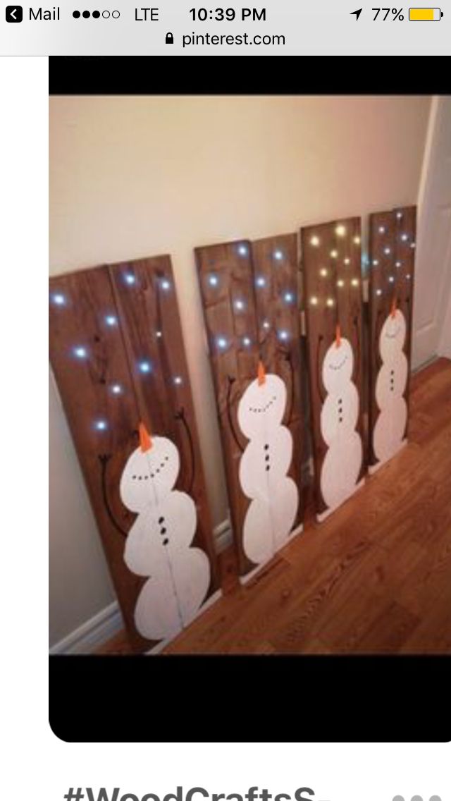 three snowmen are standing next to each other in front of a door with lights on them