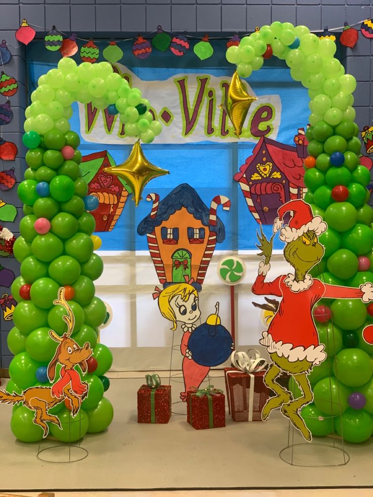 the grinch christmas decorations are set up in front of a window with balloons and presents