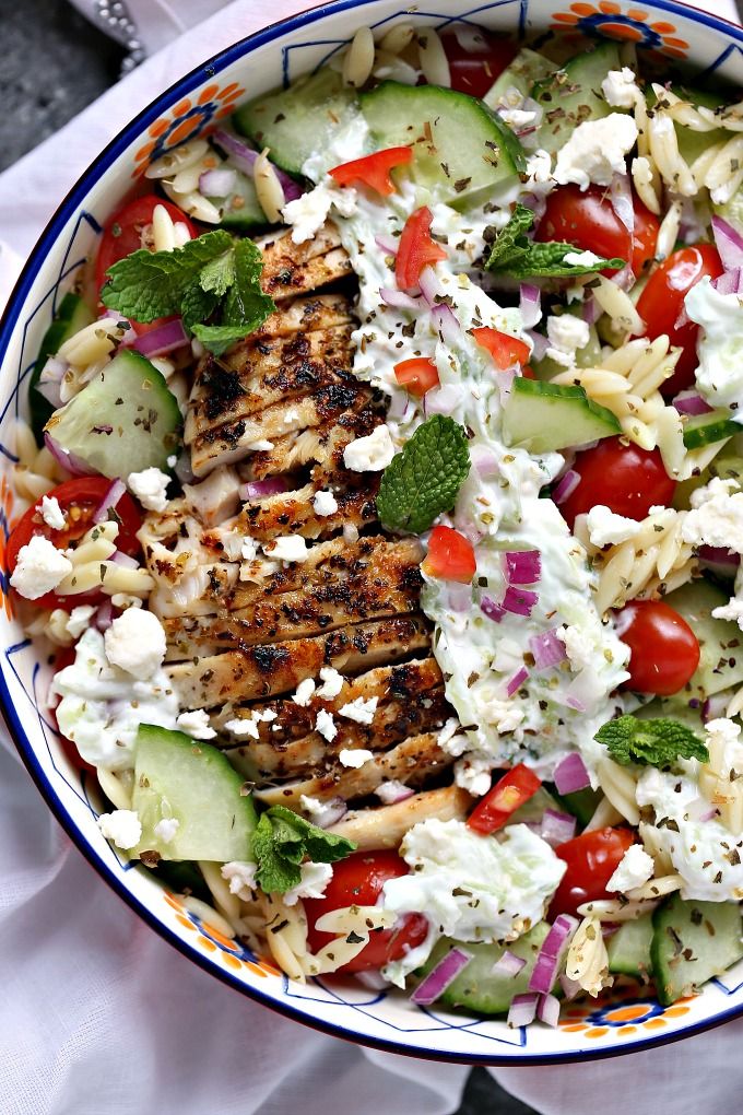 a salad with chicken, cucumbers, tomatoes and feta cheese in a bowl