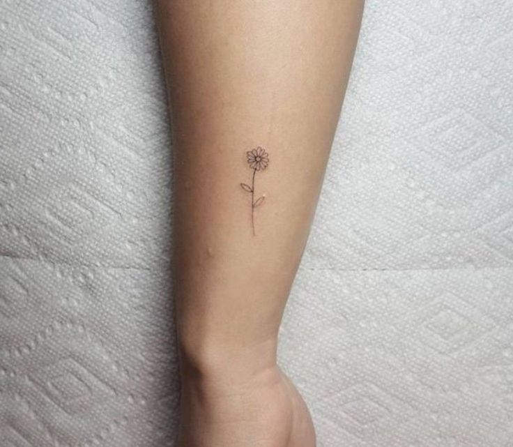 a small flower tattoo on the left calfocks is shown in this image, it looks like