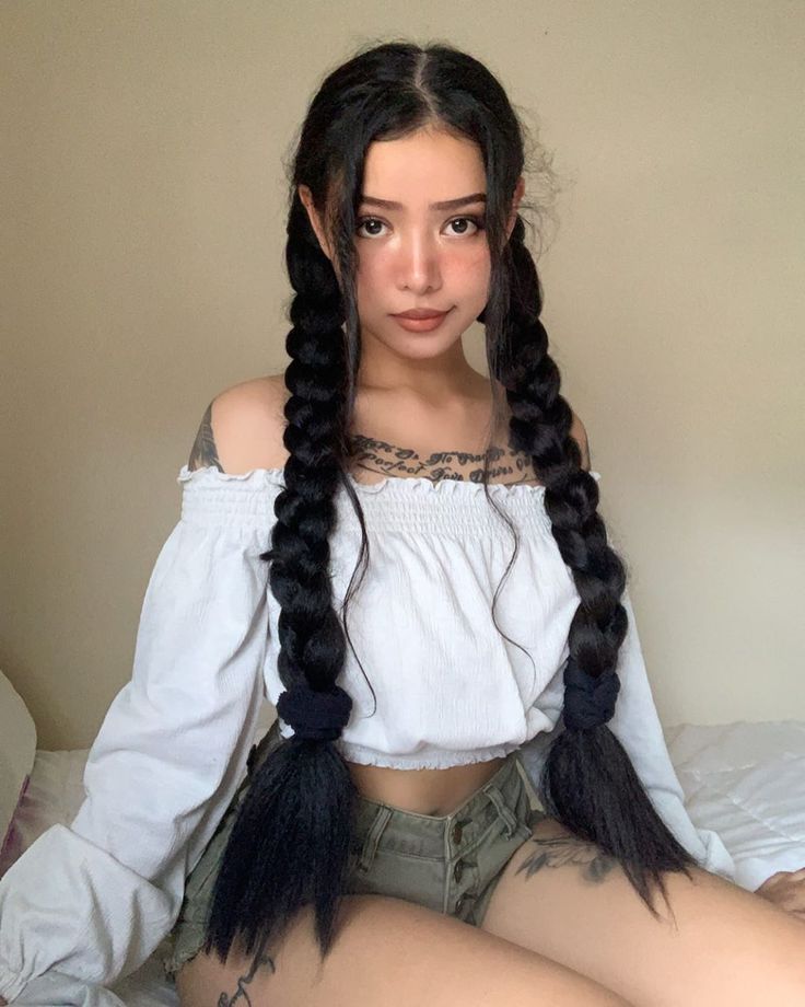 a woman with long hair sitting on top of a bed