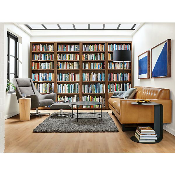 a living room filled with furniture and bookshelves covered in lots of bookcases