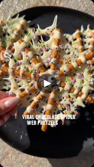 a person is holding up a plate with sprinkles on it and the words virtual chocolate spider web pretzels