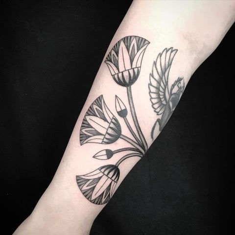 a black and white flower tattoo on the arm