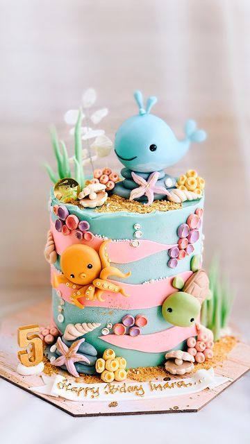 there is a cake decorated with sea animals on the top and under it, as well as other decorations