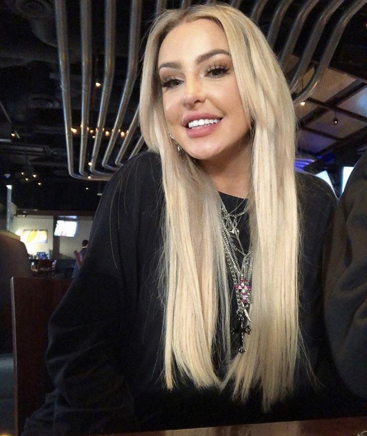 a woman with long blonde hair sitting at a table