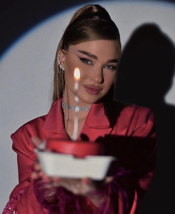 a woman holding a plate with a lit candle in it