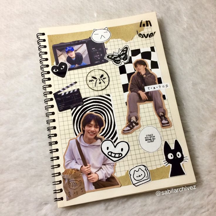 an open notebook with stickers on it and a person holding a bag in front of them