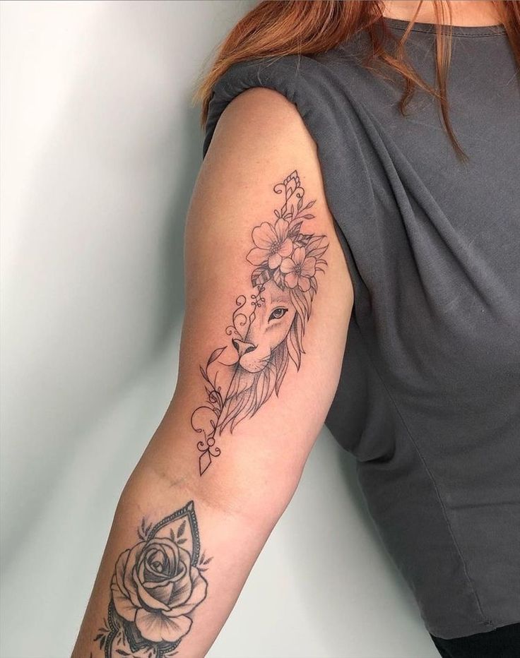 a woman with a tattoo on her arm holding a rose and a deer's head