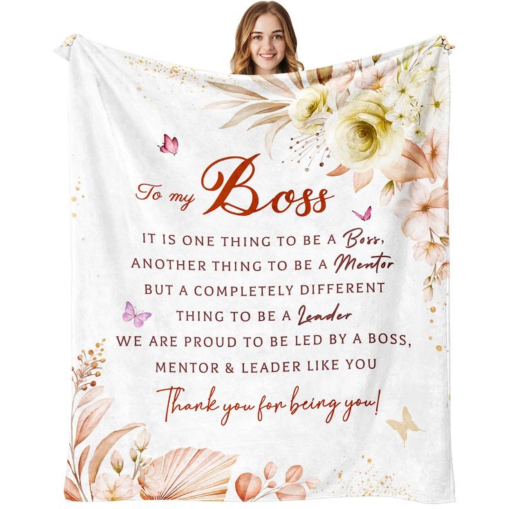 a woman holding up a white blanket with flowers on it and the words to my boss