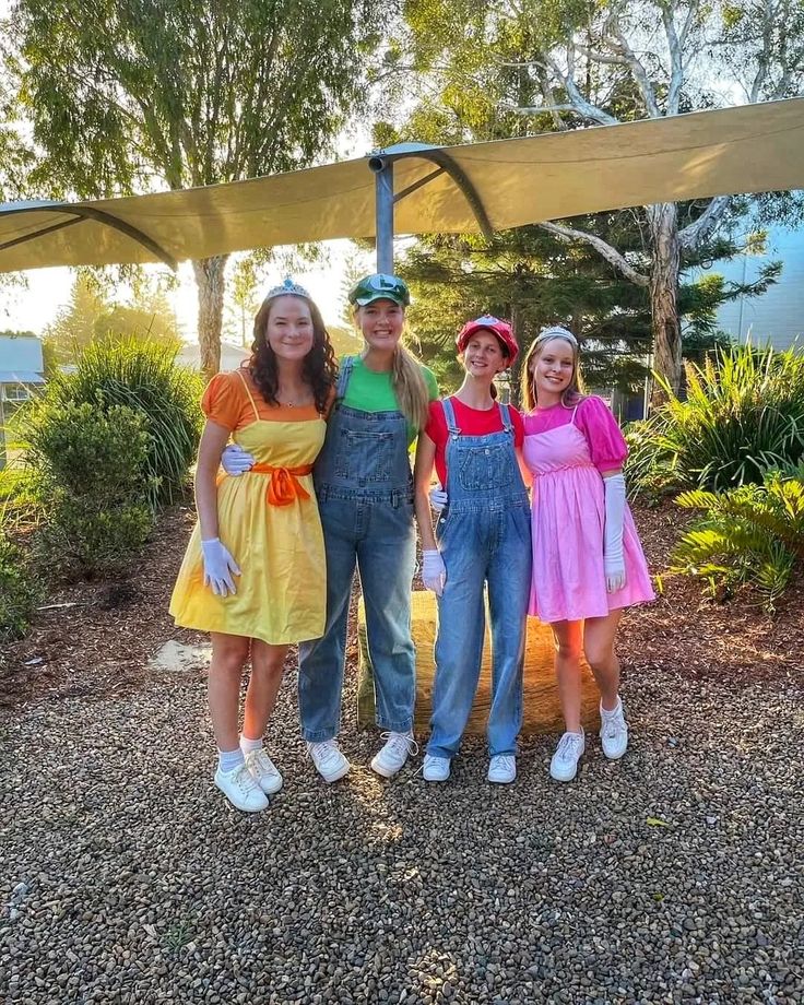 three girls and one boy are dressed up in costumes