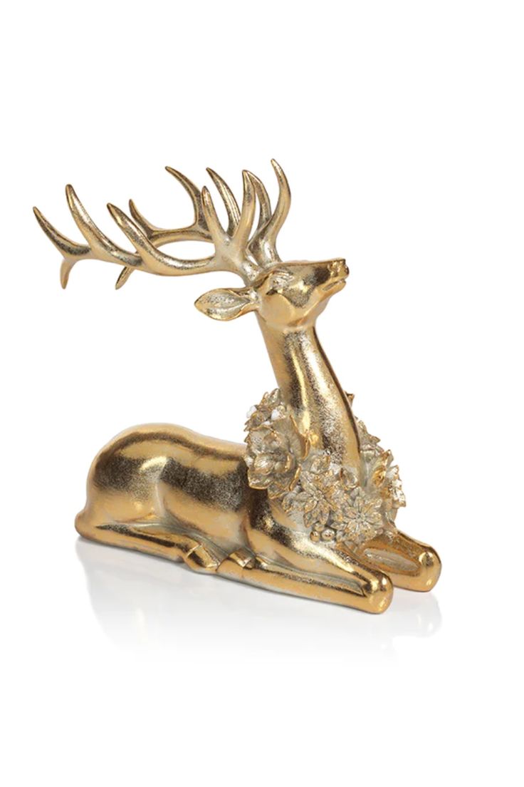 a golden deer figurine sitting on top of a white surface