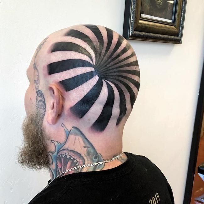 a man with a black and white striped design on his back head is shown from the neck down