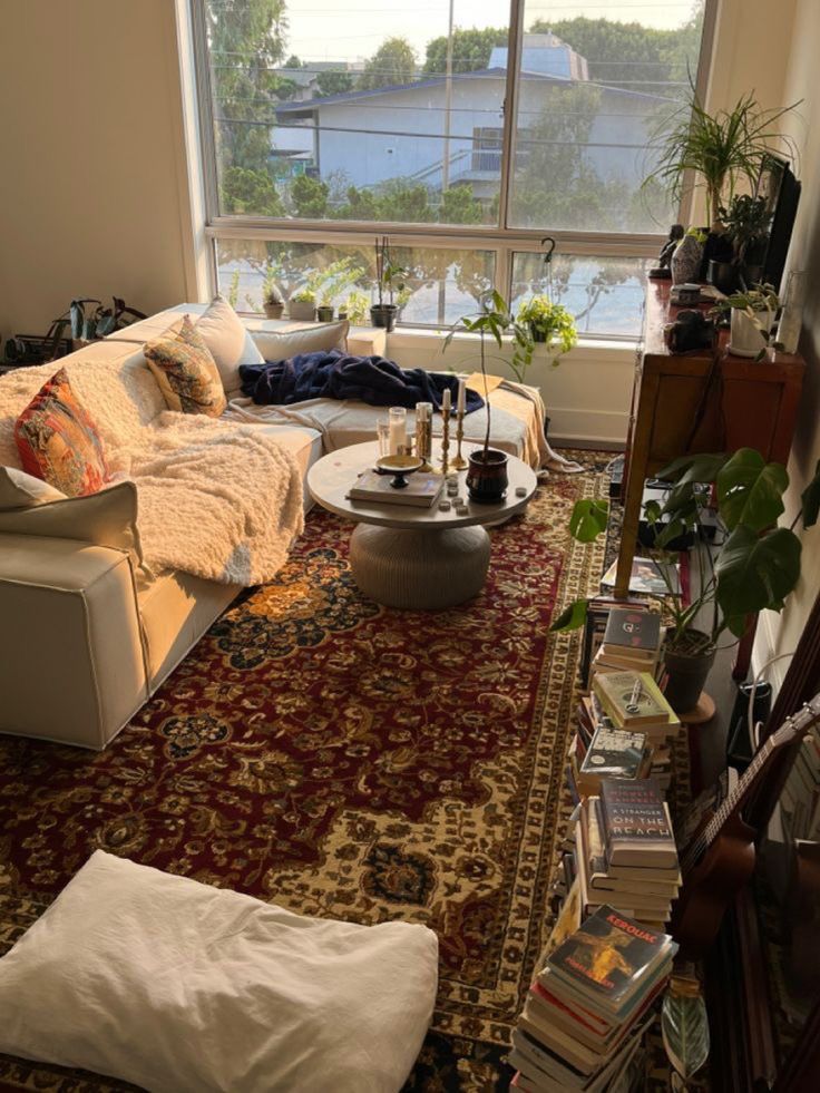 a living room filled with furniture and a large window overlooking the city below it's windowsill