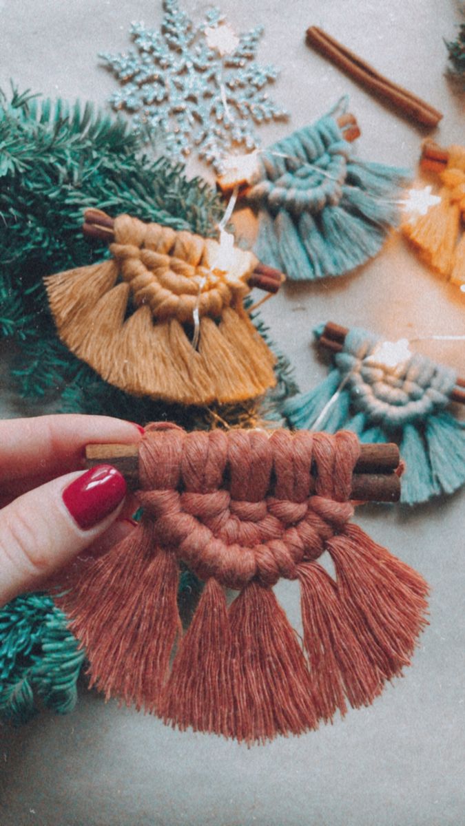 a woman's hand is holding some tassels on a table with other items