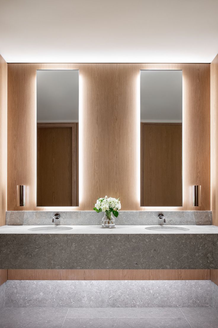 a bathroom with two sinks and three mirrors