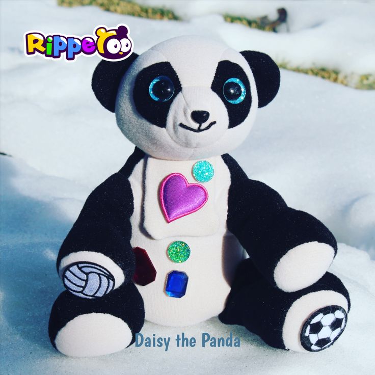 a stuffed panda bear sitting in the snow with a heart on it's chest