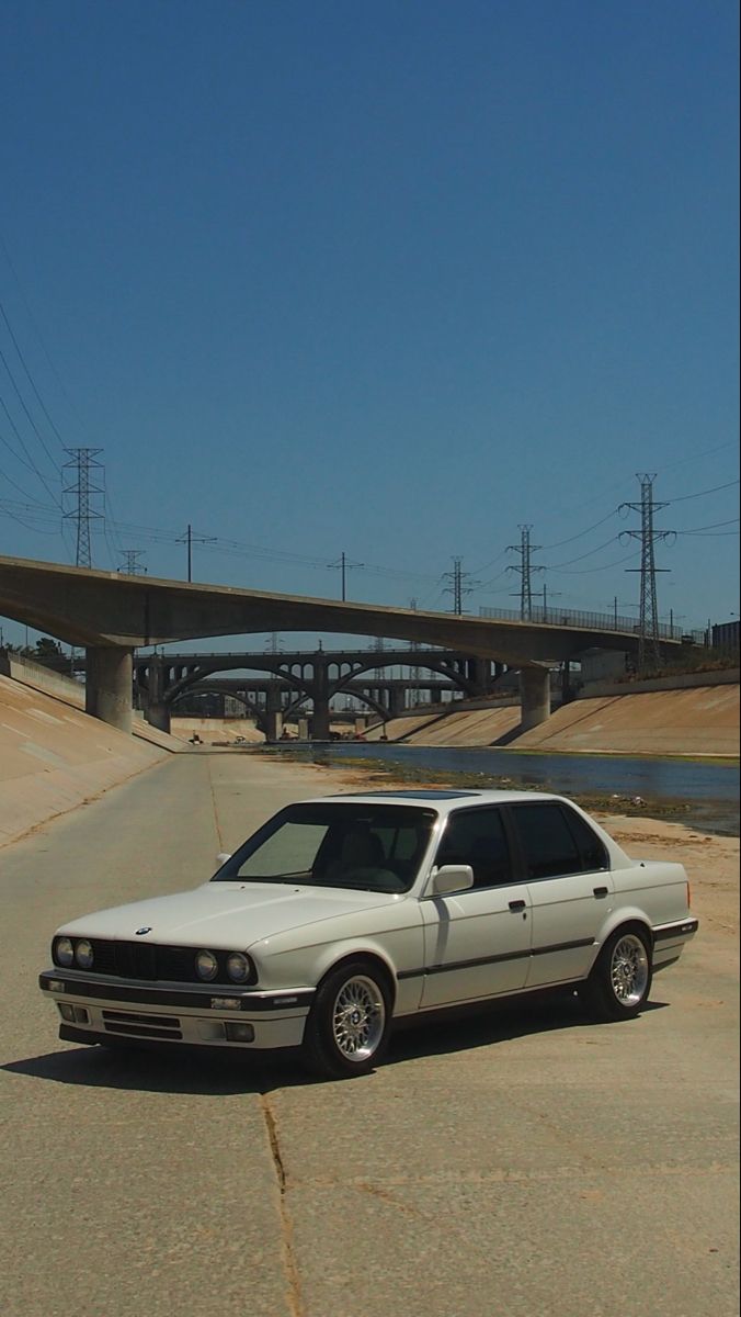 a white car parked in front of a bridge