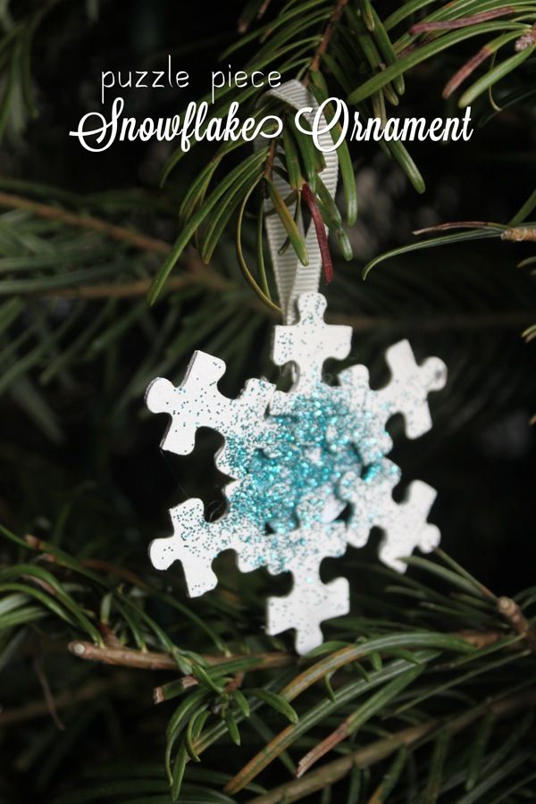 a snowflake ornament hanging from a christmas tree with the words, puzzle piece snowflake ornament