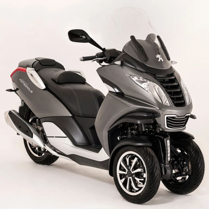 a black and silver scooter parked on top of a white floor