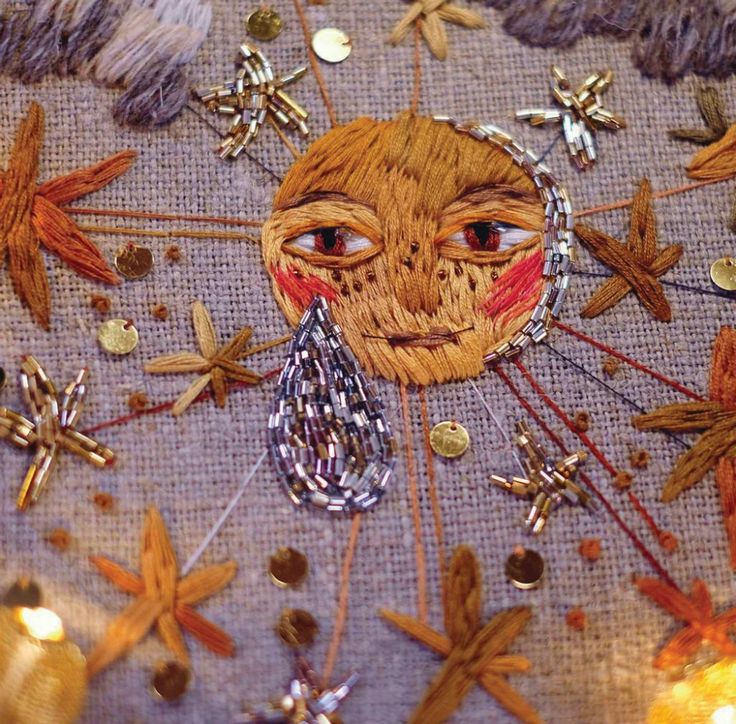 a close up of an embroidered cloth with stars and other decorations on top of it