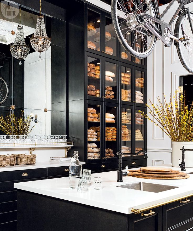 a kitchen filled with lots of counter top space next to a bike hanging from the ceiling