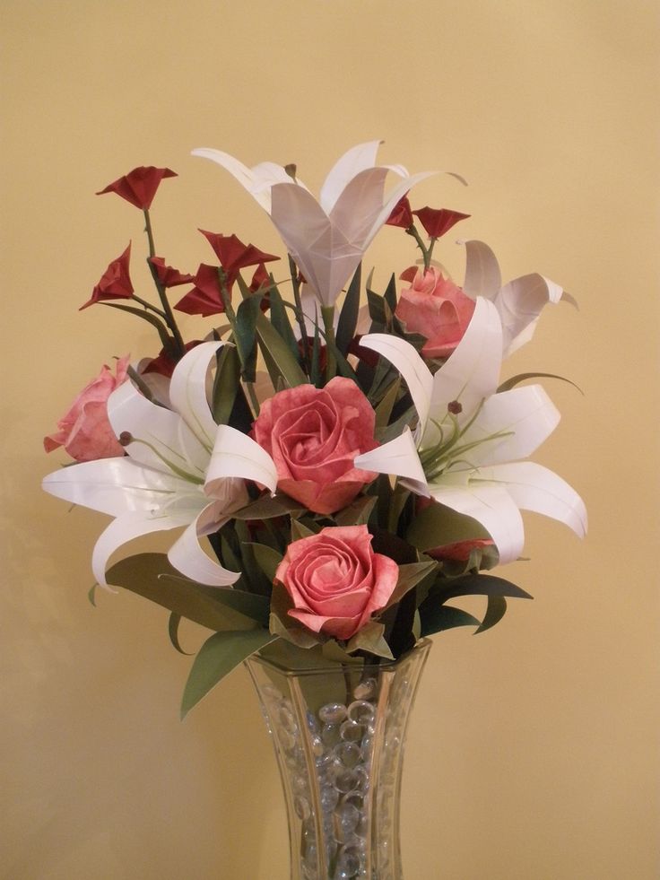 a vase filled with pink roses and white lilies