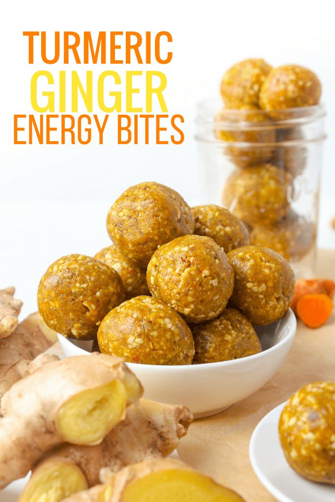 a bowl filled with carrots and ginger energy bites next to some other foods on a table