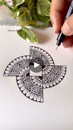 someone is drawing an intricate design on paper