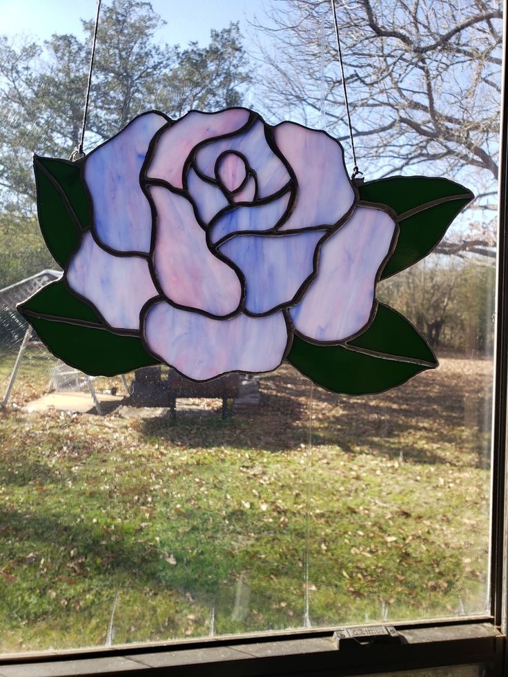 a stained glass rose hanging from a window