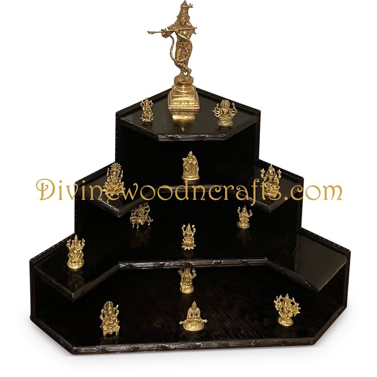 three tiered black and gold plated trays with figurines on them